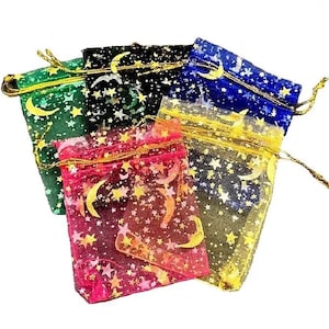 Könnte beinhalten: Fünf kleine, transparente Kordelzugbeutel in verschiedenen Farben: Grün, Schwarz, Blau, Rot und Gelb. Jeder Beutel ist mit einem goldenen Stern- und Mondmuster verziert und hat einen passenden goldenen Kordelzugverschluss.