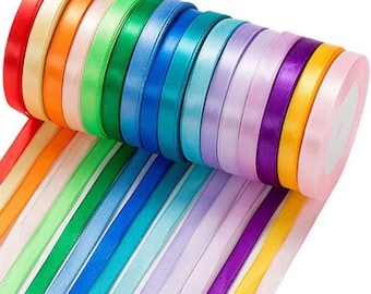 May include: A roll of colorful satin ribbon in various shades of red, orange, yellow, green, blue, purple, and pink. The ribbon is arranged in a rainbow pattern.