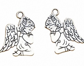 Puede incluir: Dos colgantes plateados con forma de ángel y detalles de esmalte blanco. Cada colgante presenta un ángel con las manos juntas, alas y un halo. Los colgantes tienen un lazo en la parte superior para sujetarlos.