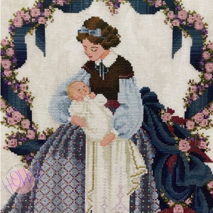 May include: A cross-stitch embroidery of a woman holding a baby. The woman is wearing a blue dress with a brown jacket and a blue ribbon in her hair. The baby is wearing a white gown. The embroidery is framed by a wreath of pink and purple flowers.