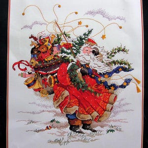 Può includere: Babbo Natale con un vestito rosso, una barba bianca e una sciarpa blu porta un sacco pieno di giocattoli e un albero di Natale. Cammina attraverso un paesaggio innevato con una ghirlanda di luci e stelle sullo sfondo.