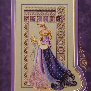 Może przedstawiać: Haftowany krzyżykiem obraz kobiety w fioletowej i złotej sukni trzymającej bukiet żółtych kwiatów. Haftowany obraz jest oprawiony w fioletową i złotą ramę. Słowo "SPRING" jest wyszyte w górnej części środkowej obrazu.