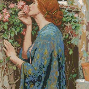 Può includere: Immagine pixelata di una donna che annusa una rosa rosa. Indossa una veste blu fantasia e ha i capelli rossi raccolti in uno chignon. Lo sfondo include un muro con fiori e un edificio.