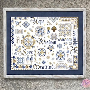 May include: A framed cross-stitch sampler featuring blue and gold geometric patterns and floral motifs on a white background. The text includes the words Hope, Wisdom, Love, Happiness, and Gratitude in a decorative font, all set within a rustic white frame.