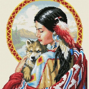 May include: A Native American woman in a colourful blanket holds a wolf pup close to her chest. She is wearing a beaded necklace and a feather headdress. The background is a scenic landscape with mountains and a river.