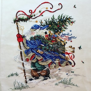 Könnte beinhalten: Ein blaugekleideter Weihnachtsmann trägt einen großen Sack voller Geschenke und einen Weihnachtsbaum auf dem Rücken und geht durch eine verschneite Landschaft, hinter ihm flattert ein rotes Band.