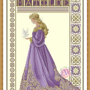 May include: Cross-stitch artwork of a woman in a purple gown holding a white dove. The name "MATILDE" is stitched at the top. The artwork is framed in a wooden frame with decorative borders.