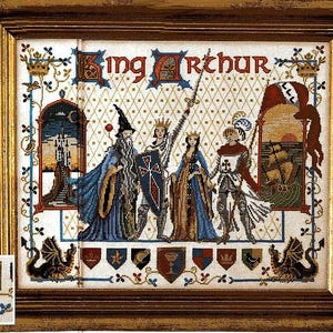 Può includere: Opera d'arte a punto croce incorniciata raffigurante Re Artù e la sua corte. L'opera presenta il testo "King Arthur" in alto, con figure dettagliate di Merlino, cavalieri e una regina. L'opera è ambientata su uno sfondo a motivi e incorniciata in una cornice di legno dorato.