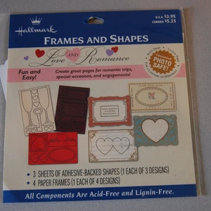 Puede incluir: Un kit de scrapbooking Hallmark Frames and Shapes Love and Romance con tres hojas de formas autoadhesivas y cuatro marcos de papel. El kit es libre de ácido y lignina. El embalaje es rosa y azul con un corazón rojo y el texto "Love and Romance".