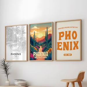 May include: Three framed prints with a desert theme. The left print shows a black and white map of Phoenix, Arizona. The middle print shows a colorful illustration of a desert landscape with cacti and a path leading to a sunset. The right print has a beige background with the text "CHASING DREAMS IN THE SKY PHOENIX EST. 1881" in orange.