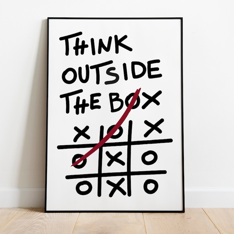 Peut inclure: Une affiche encadr&eacute;e en noir et blanc avec le texte "Think Outside The Box" &eacute;crit en marqueur noir. Une ligne rouge est trac&eacute;e en diagonale sur l'affiche, barrant le mot "box". Un jeu de morpion est dessin&eacute; sous le texte, la ligne rouge barrant un cercle dans le jeu.