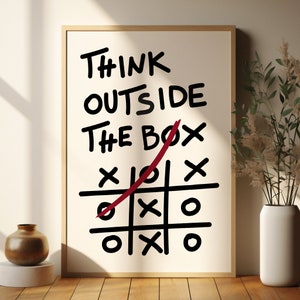 Peut inclure: Une affiche blanche avec du texte noir qui dit "Think Outside The Box" avec une ligne rouge trac&eacute;e &agrave; travers le mot "box" et un jeu de morpion dessin&eacute; en dessous.