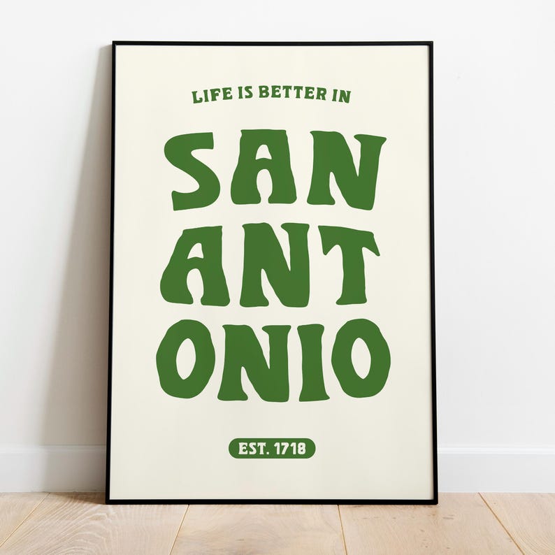 Puede incluir: Un p&oacute;ster blanco con marco negro que presenta texto verde que dice "Life is better in San Antonio Est. 1718".