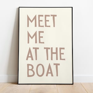 May include: A framed print with the text "MEET ME AT THE BOAT" in a light brown color on a white background.