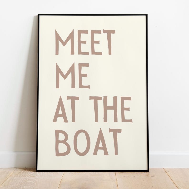 May include: A framed print with the text "MEET ME AT THE BOAT" in a light brown color on a white background.
