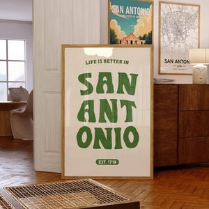 Puede incluir: Un p&oacute;ster blanco con texto verde que dice "Life is better in San Antonio" con las palabras "San Antonio" en una fuente grande y estilizada. El p&oacute;ster tambi&eacute;n incluye el texto "EST. 1718" en la parte inferior.