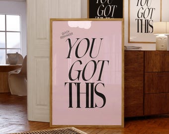 May include: Three framed posters with the text "YOU GOT THIS". One poster has a pink background, another is black, and the third is white. The posters are in a room with wooden floors and furniture.