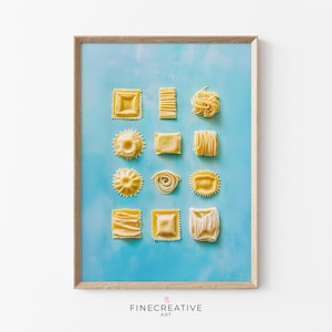 Può includere: Una stampa incorniciata con varie forme di pasta disposte su uno sfondo azzurro. La pasta comprende forme quadrate, rotonde e a spirale, con una varietà di trame. La stampa ha una cornice in legno e il testo "FINECREATIVE ART" in basso.