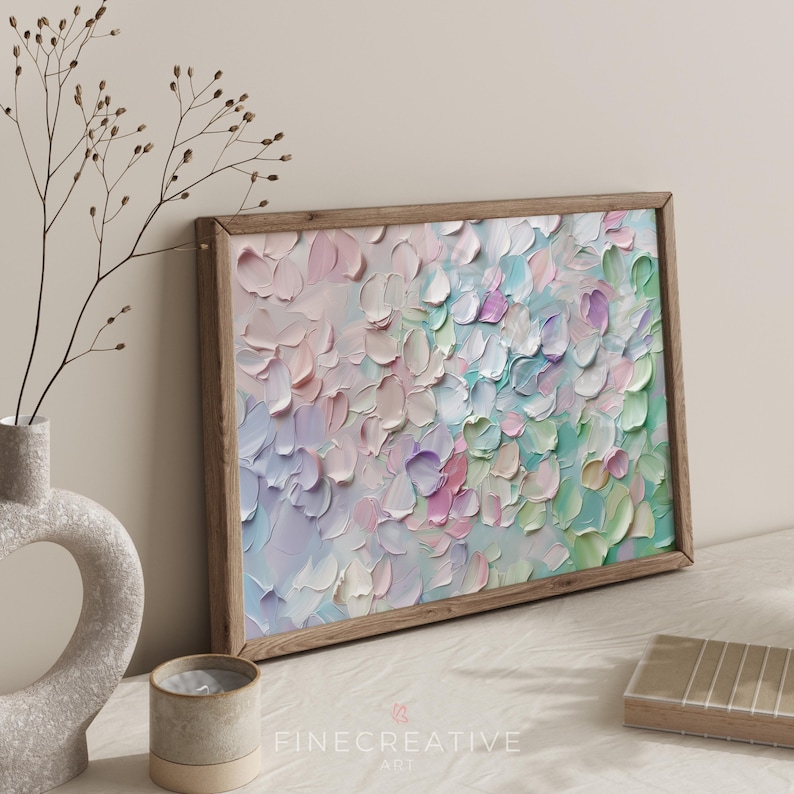 Op de afbeelding: Een ingelijst abstract schilderij met een getextureerde, impasto-stijl. Het kunstwerk heeft een palet van zachte pastelkleuren, waaronder roze, blauw, groen en paars, gerangschikt in een bloemmotief. De houten lijst voegt een natuurlijke toets toe.