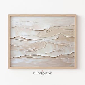 May include: Abstract painting in shades of beige and white with a textured, layered effect. The painting is framed in a light wood frame.