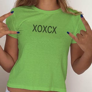 May include: A lime green short-sleeved t-shirt with the text "XOXCX" printed on the front.