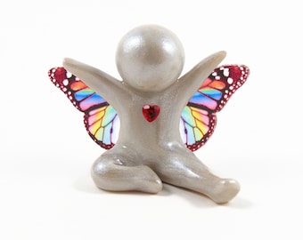 Escultura conmemorativa de un ángel bebé con corazón alegre: recuerdo de la pérdida de un hijo