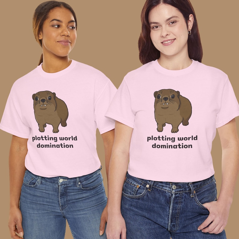 Cute brown hyrax illustration wearing a serious expression with the text “plotting world domination” printed on a t-shirt, funny animal meme graphic tee