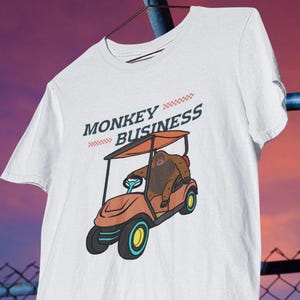 オランウータン ゴルフカート ユニセックス Tシャツ、オランウータン 運転 ゴルフカート ミーム Tシャツ、オランウータン シャツ、オランウータン ミーム、オランウータン ラバー、モンキービジネス、
