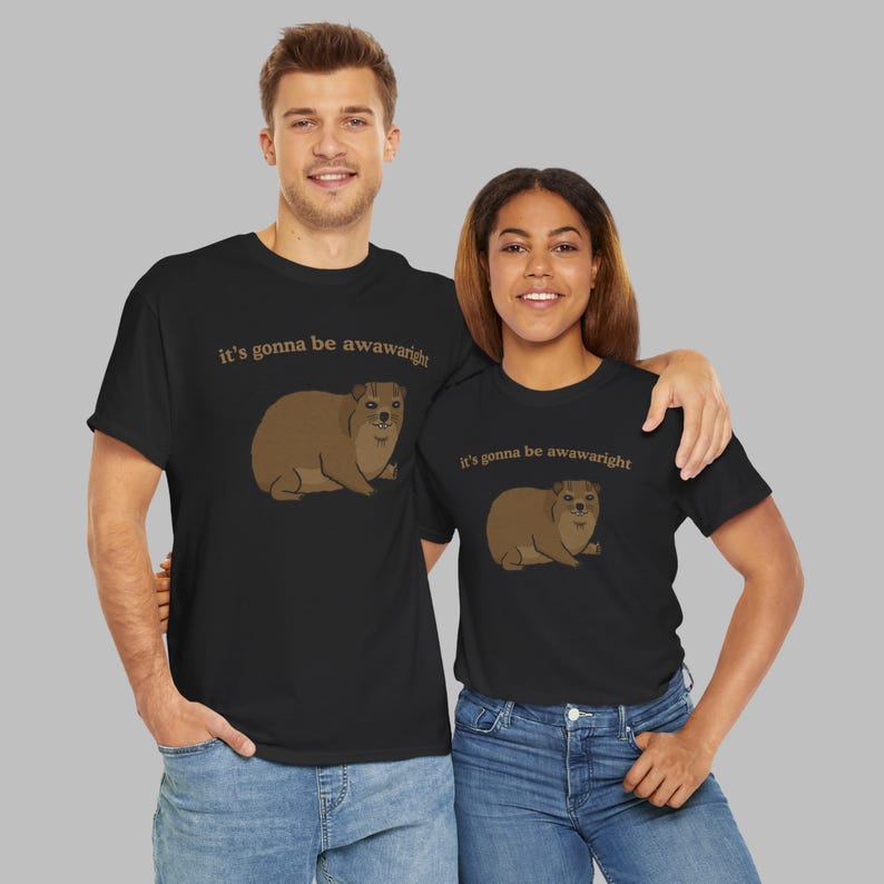 t-shirt with a cute hand-drawn hyrax illustration and the phrase ‘it’s gonna be awawaright’ — funny wholesome animal meme graphic tee.