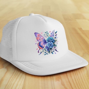 Puede incluir: Gorra de camionero blanca con un dise&ntilde;o de mariposa y flores coloridas. La mariposa tiene alas moradas, rosas y naranjas. Las flores son azules y moradas. La gorra tiene una parte trasera de malla y una visera curva.