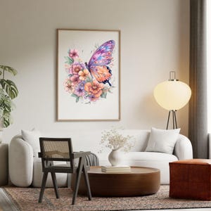 Puede incluir: Una impresi&oacute;n en acuarela enmarcada que presenta una mariposa con alas moradas, azules y naranjas, rodeada de un ramo de flores rosas, naranjas y moradas. La obra de arte se exhibe en un sal&oacute;n.