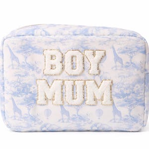 May include: A rectangular cosmetic bag with a blue and white safari print featuring giraffes and hot air balloons. The words "BOY MUM" are embroidered in fluffy white letters with gold trim. The bag has a gold zip.