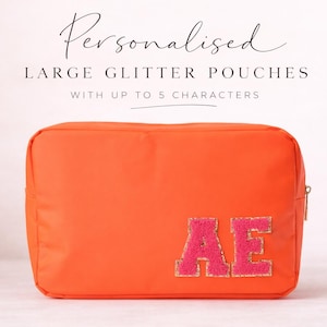 May include: A bright orange pouch with a gold zip and pink glitter letters spelling "AE". The text above reads "Personalised Large Glitter Pouches With Up To 5 Characters".