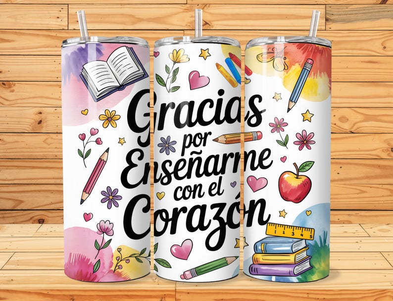 Pu&ograve; includere: Tre bicchieri in acciaio inox bianco con un design colorato. I bicchieri presentano uno sfondo ad acquerello con fiori, matite, libri e un cuore. Il testo sui bicchieri recita "Gracias por ense&ntilde;arme con el coraz&oacute;n".