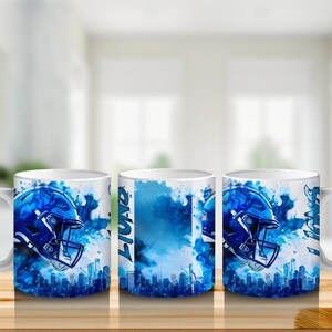 Puede incluir: Taza de cer&aacute;mica blanca con un dise&ntilde;o de casco de f&uacute;tbol azul y una silueta de ciudad. La taza presenta la palabra "LIONS" en fuente vertical. El dise&ntilde;o incorpora efectos de acuarela azules. Ideal para bebidas.