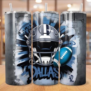 May include: Three stainless steel insulated tumblers with a football theme. Each tumbler features a football helmet, football, and the word "DALLAS" in a graffiti style design. The background has a distressed, textured look with shades of gray and blue.