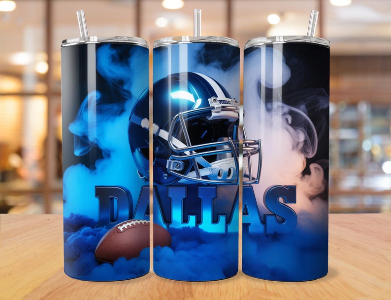 May include: Three stainless steel tumblers with a Dallas Cowboys theme. Each tumbler features a blue football helmet, a brown football, and the word "DALLAS" in blue. The design is set against a backdrop of blue smoke.