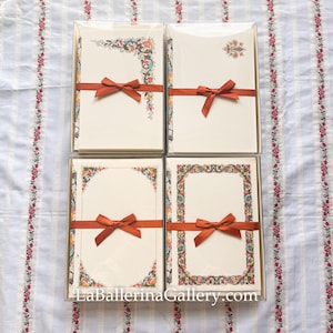 Peut inclure: Quatre ensembles de papeterie sont présentés, chacun enveloppé d'un ruban couleur rouille. La papeterie présente des motifs floraux et ornés de différentes couleurs. Le texte "LaBallerinaGallery.com" est visible en bas de l'image.