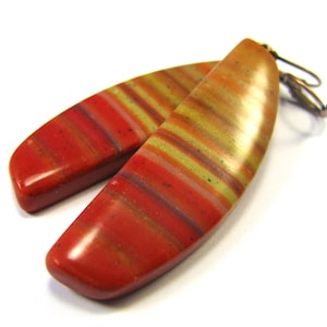 May include: A pair of long, red, yellow and brown striped dangle earrings with a silver hook.