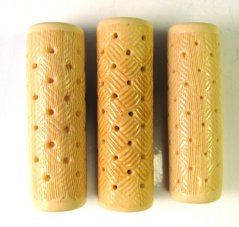 Puede incluir: Tres objetos cil&iacute;ndricos beige con una superficie texturizada y m&uacute;ltiples agujeros. Los objetos est&aacute;n hechos de un material que se asemeja a la madera.