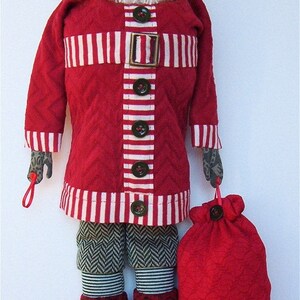 May include: A red and white striped quilted jacket with a red felt bag. The jacket has a white faux fur beard and a red hat with a white pom-pom. The jacket has a belt with a metal buckle and buttons down the front.