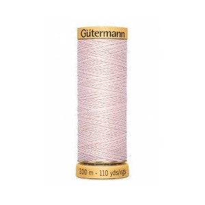 May include: A spool of Gütermann sewing thread in a pale pink shade. The spool is made of wood and features a label that reads "Gütermann" and "100 m - 110 yds/yds".