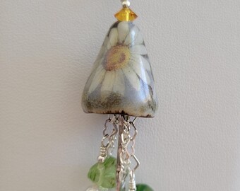 Keramische hanger met madeliefjesmotief en sterling zilveren "Hij houdt van mij"-citaat.