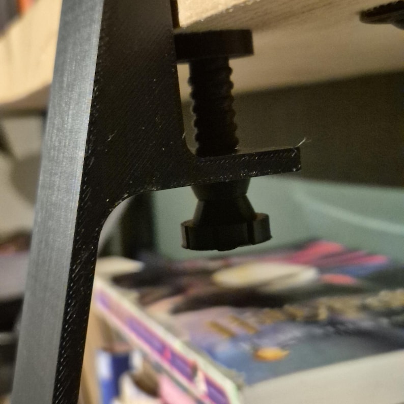 May include: A black plastic desk leg with a threaded screw and a black plastic foot.