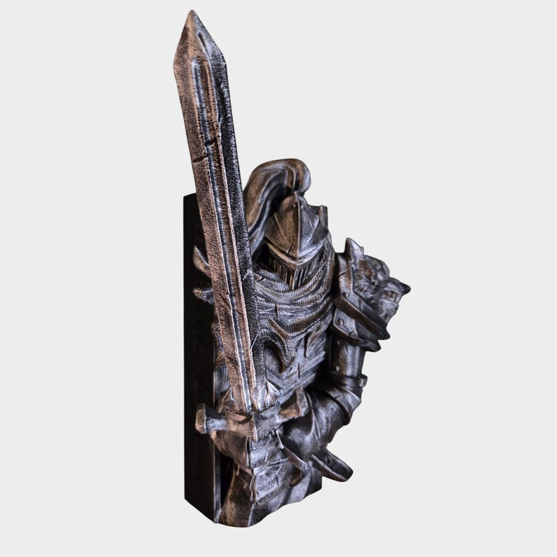May include: A detailed, silver-colored knight figurine holding a sword. The knight is clad in armor with a helmet and a wolf's head on the shoulder. The figurine is mounted on a black base, showcasing intricate details and textures.