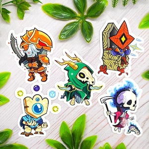 May include: A collection of five fantasy-themed stickers. The stickers feature cartoon characters in various poses, including a knight with a sword, a grim reaper, and other mystical figures. The stickers are colorful and detailed.