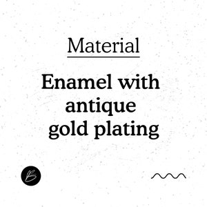 K&ouml;nnte beinhalten: Text, der "Material" mit einer Linie darunter lautet. Unter dem Text steht "Enamel with antique gold plating".