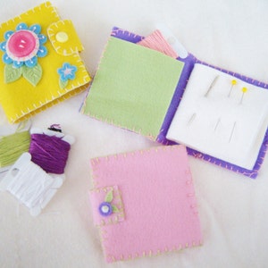 May include: Three small felt sewing kits with different colors and designs. The kits include needles, thread, and a small flower embellishment.