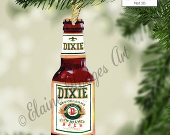 May include: A wooden Christmas ornament shaped like a beer bottle. The bottle is brown with a green label that says "Dixie New Orleans Slow Brewed Beer".