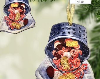 May include: A blue and white Christmas ornament depicting a pot of crawfish, corn, and potatoes. The ornament is two-sided and flat, not 3D. The text "2 Sided 2D Flat Ornament Not 3D" is printed on the ornament.